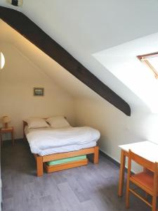 蓬蒂维Auberge de Jeunesse HI Pontivy的一间卧室配有一张床和一张木桌