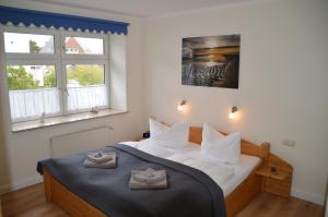 维滕Hotel Südstrand Amrum的一间卧室配有一张床,上面有两条毛巾