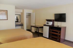 莱克维尤Oregon Trail Inn and Suites的一间酒店客房,设有两张床和电视