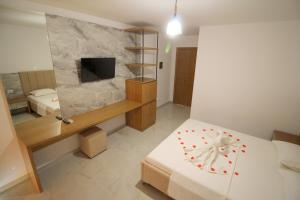 卡萨米尔Hotel Four Islands的一间卧室配有一张床和一台电视。