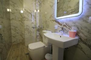 卡萨米尔Hotel Four Islands的一间带水槽、卫生间和镜子的浴室
