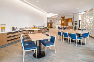 三角洲杜华逊海岸酒店的一间配备有桌子和蓝色椅子的用餐室