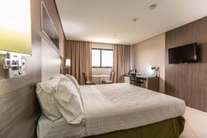 库亚巴Hotel Inter Cuiaba的酒店客房设有一张大床和一张书桌。