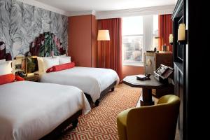 华盛顿Riggs Washington DC的酒店客房,配有两张床和椅子