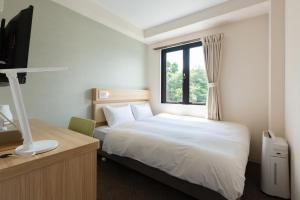 日出町fico HIJI的酒店客房设有床和窗户。