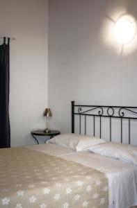 雷焦艾米利亚拉罗斯塔酒店的一间卧室配有一张床和一张桌子上的台灯