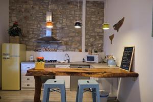 圣温琴佐OlioeAlloro B&B的厨房配有木制台面和蓝色凳子