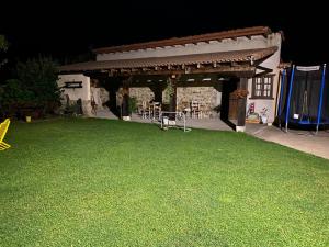 MuñecaLas Riendas casa rural的后院设有凉亭和绿色草坪