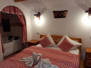 Căpăţîneni-PămînteniCABANUTE si CAMPING DRACULA的一间卧室配有一张带红色和白色床罩的床。