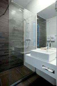 亨克爱酷酒店的一间带水槽和玻璃淋浴的浴室