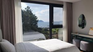 西归浦市Hotel Seogwipean的卧室设有海景大窗户