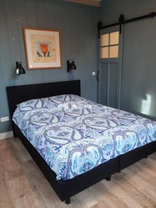 阿姆斯特丹B & B Tulp Amsterdam Noord的卧室内的一张带蓝色和白色棉被的床
