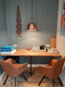 阿姆斯特丹B & B Tulp Amsterdam Noord的一张木桌,配有两把椅子和一盏灯