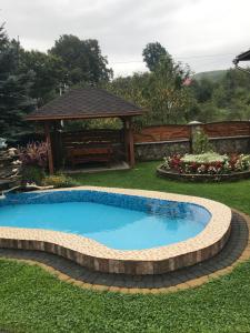 YablunivVacation home的一个带凉亭的庭院内的游泳池