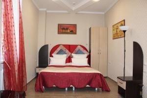 基兹洛沃茨克Hotel Atlantida的一间卧室配有一张红色床头板的床