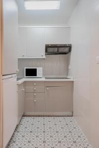 贝纳尔马德纳Apartamento Marina Suite的厨房配有白色橱柜和微波炉