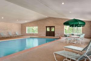 Whitmore Lake惠特莫尔湖最佳西方酒店的一个带椅子和桌子的游泳池以及一把遮阳伞