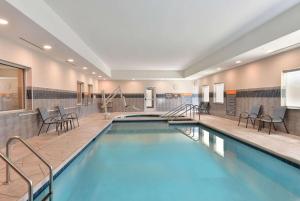 威斯康星戴尔La Quinta Inn & Suites by Wyndham Wisconsin Dells- Lake Delton的游泳池位于酒店带椅子的客房内,游泳池