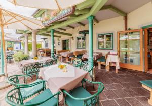 奥伊根多夫德里埃岑乡村酒店的一间带桌椅和遮阳伞的餐厅