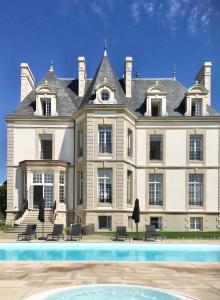 贝诺代Les Garennes - Hôtel Spa Bénodet的一座大房子前面设有一个游泳池