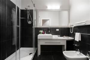 敖德萨优诺设计酒店的黑白浴室设有水槽和浴缸。