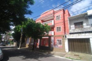 福塔莱萨Refúgio Pousada Fortaleza的街道边的粉红色建筑