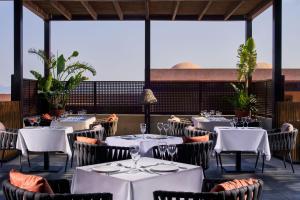 卡尔扎迈纳Atlantica Belvedere Resort - Adults Only的一间设有白色桌椅的餐厅