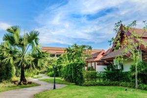 奈扬海滩L'esprit De Naiyang Beach Resort - SHA Extra Plus的前面有棕榈树的房子
