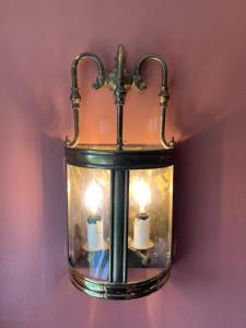 亨利昂泰晤士汗布尔登雄鹿与猎人旅馆的挂在墙上的灯笼,上面有两根蜡烛