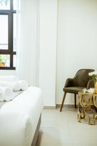 贝尔谢巴The Negev Hotel By Domus的一间卧室配有一张床、一把椅子和一张桌子