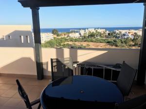 维拉Atico con piscina privada y vistas al mar的海景阳台上的桌椅