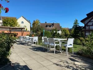施泰因Garni-Hotel Mühletal的庭院里一排白色的桌椅
