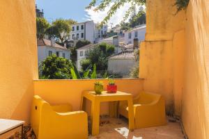 辛特拉卡萨达潘多酒店的阳台上的小黄桌子和椅子