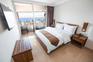 亚喀巴Joar Beach Hotel的酒店客房设有一张床和一个大窗户