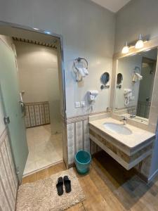 塔诺马أزد للشقق المخدومة的一间带水槽、镜子和淋浴的浴室