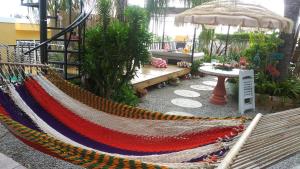拉帕尔格拉Casa Bonita Inn的花园内的吊床,配有长凳和遮阳伞