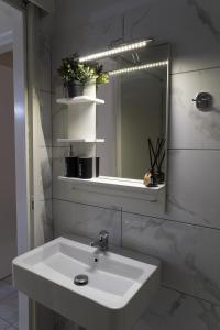 克拉默特Melanthi Apartment的浴室设有白色水槽和镜子