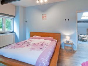 XhoffraixHoliday Home in Xhoffraix between Spa and Eifel Nature Park的一间卧室配有一张带粉红色棉被的床