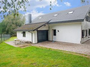 XhoffraixHoliday Home in Xhoffraix between Spa and Eifel Nature Park的一间白色的房子,有车库和草地庭院