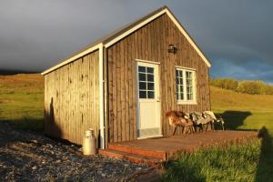 瓦玛里德Sólheimagerði Guesthouse的一座小型木结构建筑,外面有动物