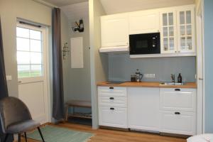 瓦玛里德Sólheimagerði Guesthouse的厨房配有白色橱柜、水槽和微波炉
