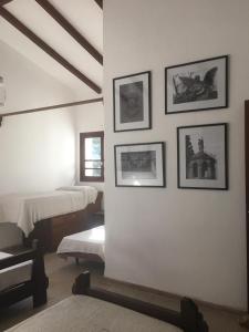 里奥塞瓦约斯Villa Anedé的卧室配有一张床,墙上挂有图片