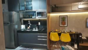 马塞约Time Home Service 1411的厨房配有桌子和2把黄色椅子