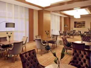 伊斯坦布尔美居伊斯坦布尔阿尔图尼匝德酒店的一间在房间内配有桌椅的餐厅