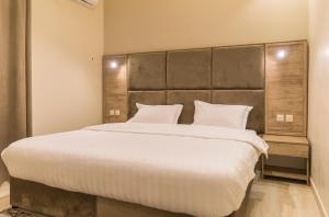 拉夫哈فندق وفود的卧室配有一张带白色床单和枕头的大床。