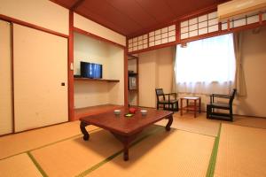 对马市Banshoukaku的客厅配有桌椅和窗户。
