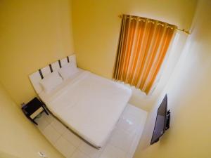 泗水City Residence Kutai 32的小房间设有白色的床和窗户