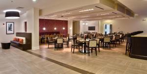 夏洛特夏洛特机场假日酒店的一间在房间内配有桌椅的餐厅