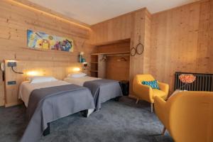 科特雷阿斯德黑萨卡酒店的酒店客房,设有两张床和一张黄色椅子