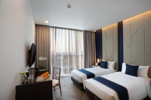 雅加达ASTON Kemayoran City Hotel的酒店客房设有两张床和电视。